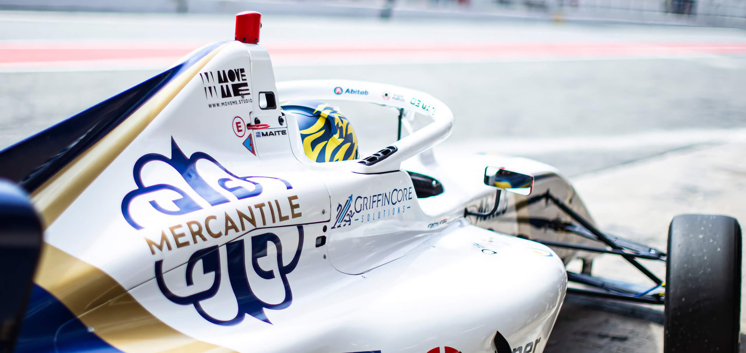 Mercantile Bank International branded race car in the pit lane, part of the bank's F4 racing sponsorship.